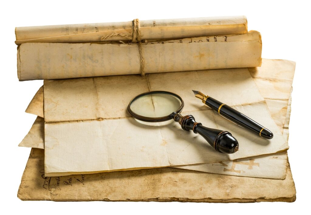 Fountain pen and magnifying glass with old sheets